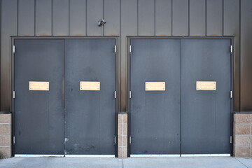 Two double doors used as emergency exits on back of large theatre.