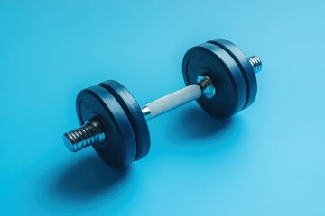 Naklejka premium A single dumbbell lies on a vibrant blue surface