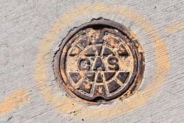 Natural gas line access port on city street.