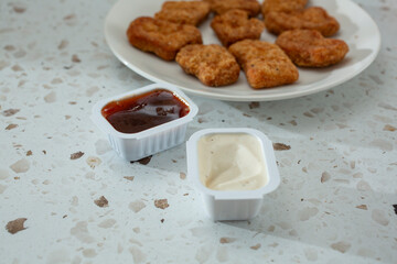 A view of restaurant style portion cups, featuring BBQ sauce and ranch dressing.