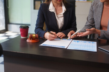 Close-up of two female lawyers hands working at desk, handling legal documents, drafting contracts and preparing for business meetings, specializing in legal and corporate legal services
