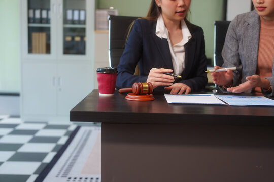 Close-up of two female lawyers hands working at desk, handling legal documents, drafting contracts and preparing for business meetings, specializing in legal and corporate legal services