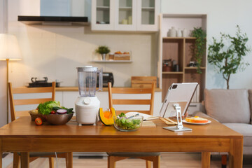 Fresh vegetables and fruits with a blender placed on the kitchen table, representing good health...