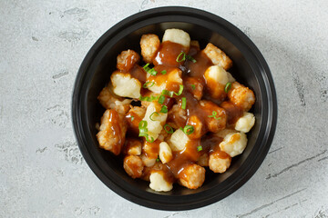 A top down view of a bowl tater tots poutine.