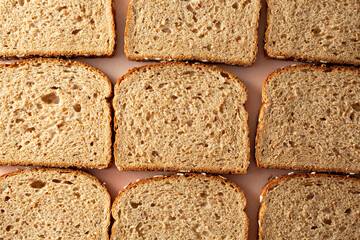 A top down view of a layer of whole grain wheat bread slices, as a background.