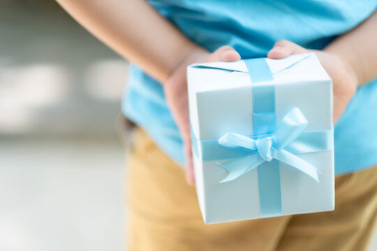 Close up kid hand hold blue gift box behide his back Focus at prestent celebrate for father day, birth day.