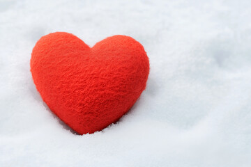 Fototapeta premium Soft red felt heart resting on fresh white snow symbolizing love warmth and romance in winter season