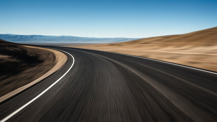 The curved asphalt pavement has distant mountains and sky background in depth perspective