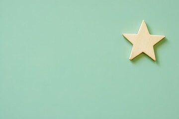 Fototapeta premium A wooden star decorates a plain light green colored backdrop