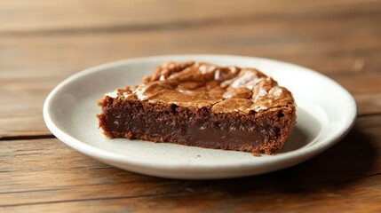 Gooey Chocolate Brownie Slice on a Light Plate with Wooden Background