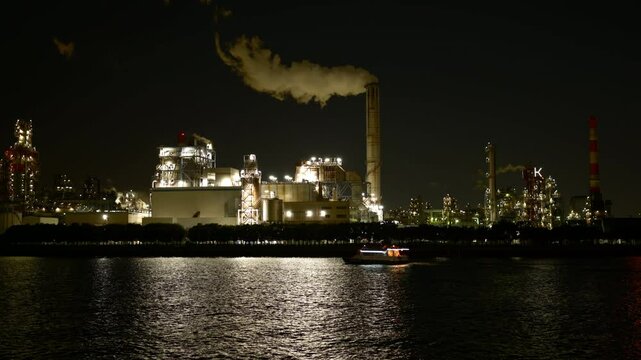 川崎の工場夜景の鑑賞を目的したツアー客を乗せたボートが運河を横切るシーン（製油所・火力発電所）（リアルタイム・ズームアウト）