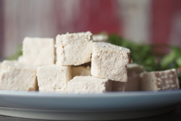 Freshly cut tofu served on a plate with herbs