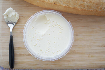 Creamy spread with fresh bread placed on wooden board
