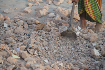Construction worker clearing rubble at a site in daylight