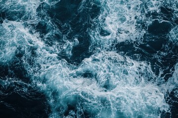 Fototapeta premium Turbulent sea waves creating white foam patterns and dark depths