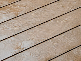 Rain on the wooden floor surface.