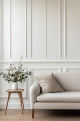 Minimalist living room with beige sofa, wainscoting, and floral arrangement.