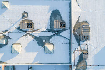 A roof covered in snow, with a few vents and chimneys visible © Tracy King