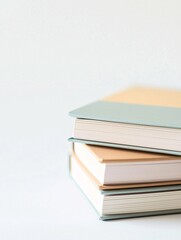 A minimalist stack of notebooks in soft pastel hues elegantly arranged on a white background, perfect for branding, stationery design, or educational use.