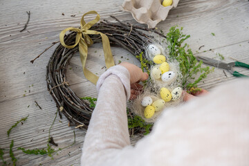 Step by step instruction of making handmade Easter wreath made of sustainable materials decorations in yellow color. Female hands creating craft homemade decor. Easter celebration gift present ideas