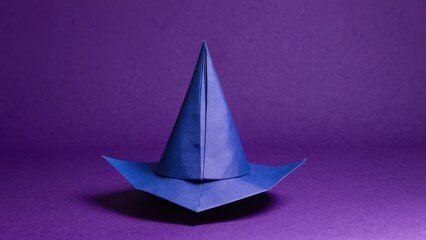 Fototapeta premium A whimsical paper witch hat stands out against a vibrant purple backdrop