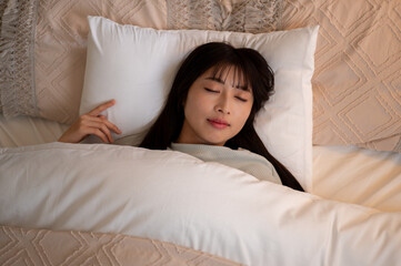 ベッドで眠る日本人女性