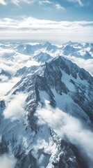 Fototapeta premium Drone capture of a breathtaking mountain range covered in snow, with clouds casting dynamic shadows over the peaks