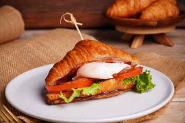 Croissant bread and poached eggs, vegetables and ham Breakfast on the table