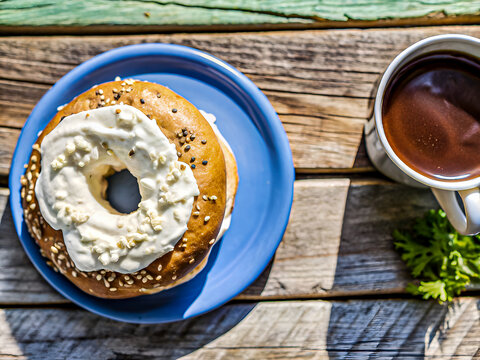 Delicious freshly baked bagel with cream cheese and a coffee cup. Tasty food and drink  background