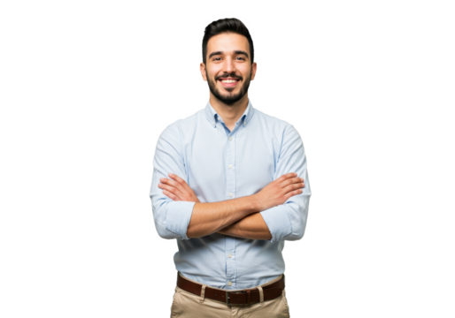 A young man wearing a light blue button-up shirt and beige pants standing with arms crossed and smiling confidently