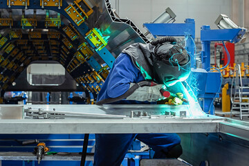 Welder working with electrode at semi automatic arc welding in manufacturing production plant. Plasma welding. No AI tools