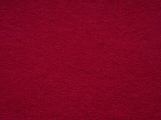 A luxurious expanse of deep red felt, evoking warmth and sophistication in its sumptuous texture