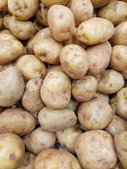 Top-down view of a neatly stacked display of fresh potatoes. Earthy brown potatoes arranged in an organized pattern, highlighting their natural texture and rustic appearance.