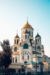 Orthodox church with golden domes. Church Golden sunset. Place of worship of God. Shining domes of the church.