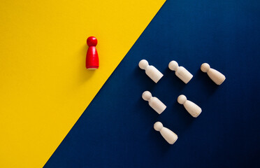 Red wooden pawn separating from group of white pawns: concept of leadership and business strategy