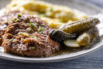 Inverted Beef Schnitzel with Mashed Potatoes and Pickled Cucumbers. Traditional Czech and Slovak Food