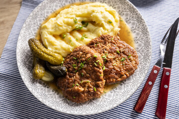 Inverted Beef Schnitzel with Mashed Potatoes and Pickled Cucumbers. Traditional Czech and Slovak Food