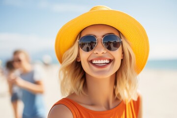 A woman wearing a yellow hat and sunglasses is smiling at the camera