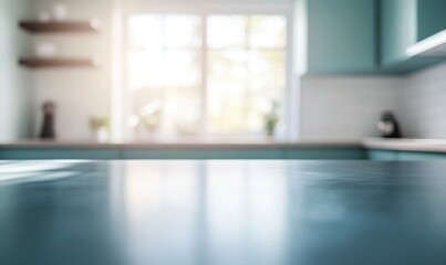 A blurred background of an empty kitchen countertop with teal cabinets and white walls, with light streaming in from the window