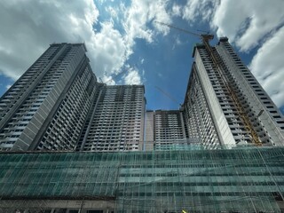 A building under construction, with scaffolding wrapping around the structure, showcasing ongoing progress, skyscrapers in the city