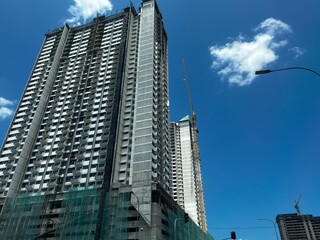 A building under construction, with scaffolding wrapping around the structure, showcasing ongoing progress, skyscrapers in the city