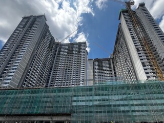 A building under construction, with scaffolding wrapping around the structure, showcasing ongoing progress, skyscrapers in the city