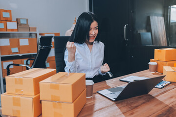 Asian SME business women use laptop computer checking customer order online shipping boxes at home....