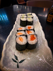 A long plate of sushi with fresh nigiri and colorful rolls, beautifully arranged with wasabi and ginger on the side. Perfect for sushi lovers!
