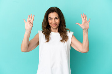 Fototapeta premium Middle aged caucasian woman isolated on blue background counting nine with fingers