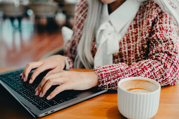 Stylish Woman Working on Laptop with Coffee in Modern Café Setting, Business concept