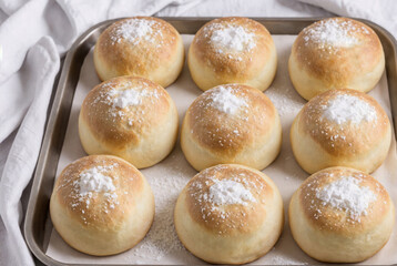 Fresh, delicious buns in a baking mold, top view. Crispy freshly baked buns