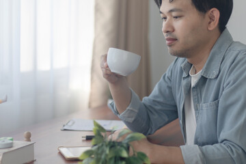A young man is drinking a cup of coffee.