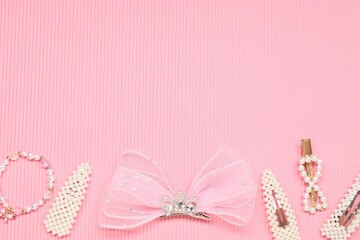 Different hair accessories on pink textured background, flat lay. Space for text
