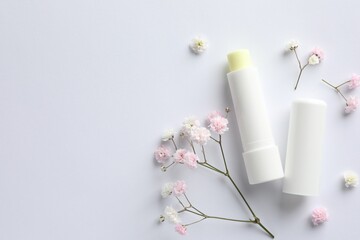 Lip balm and gypsophila flowers on white background, flat lay. Space for text
